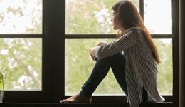 Woman sitting and looking out of a window