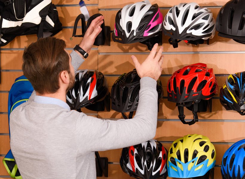 Man at a store choosing a helmet to purchase