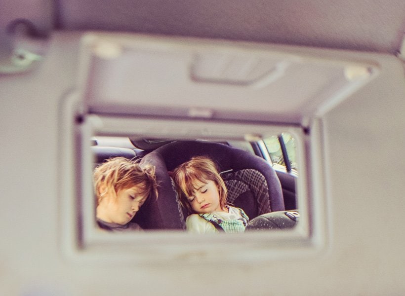 Kids sleeping in the back seat of a car