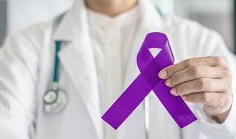 Doctor holding a purple ribbon