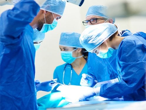 Clinicians gathered around a patient on an operating table