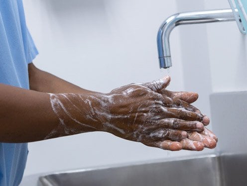 Clinician washing their hands with soap and water