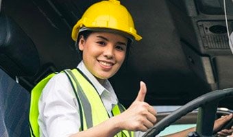 Female sitting behind steering wheel of a large vehicle